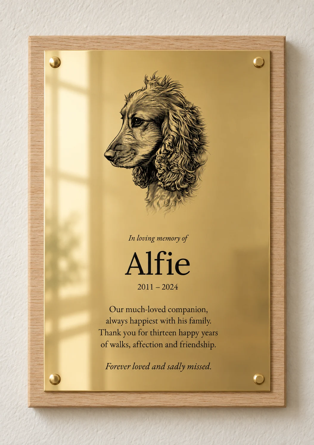 Spaniel portrait memorial for Alfie, 2011–2024, in polished brass on square-edged light oak with brass screw caps